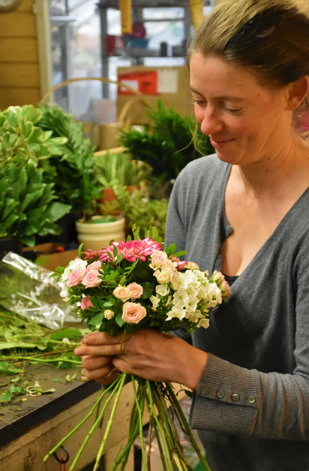 Une fleuriste tient un bouquet dans sa boutique